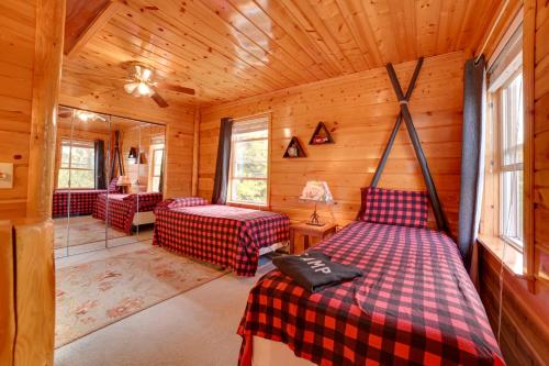 1 dormitorio con 2 camas en una cabaña de madera en Riverfront Cheboygan Cabin with Kayaks and Dock!, en Cheboygan