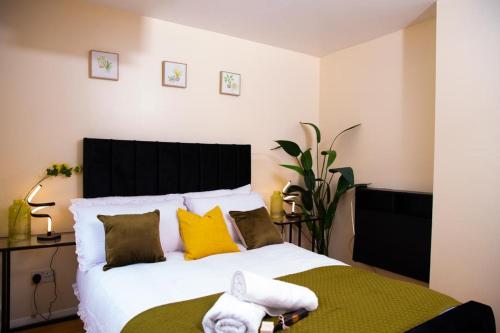 a bedroom with a large white bed with yellow pillows at Inviting 1-Bed Apartment in London near Hotsput in London