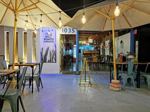 a restaurant with tables and chairs and a tent at Hostel Punto Cavancha in Iquique