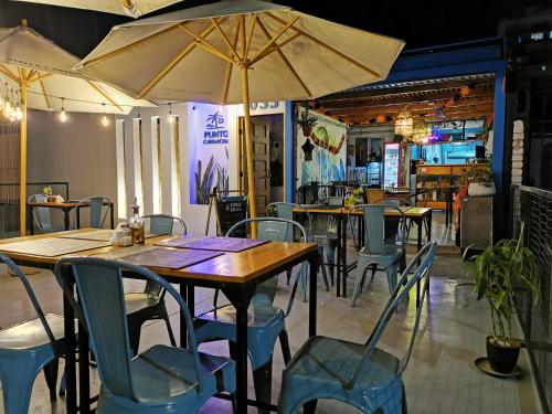 an empty restaurant with tables and chairs and umbrellas at Hostel Punto Cavancha in Iquique