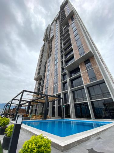 a large building with a swimming pool in front of it at Lux 2 bedroom apartment, swimming pool, gym and free parking spot in Macro Plaza area in Monterrey