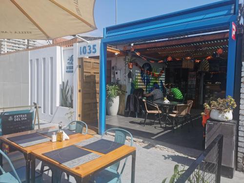 un patio con mesas y sillas fuera de un restaurante en Hostel Punto Cavancha, en Iquique