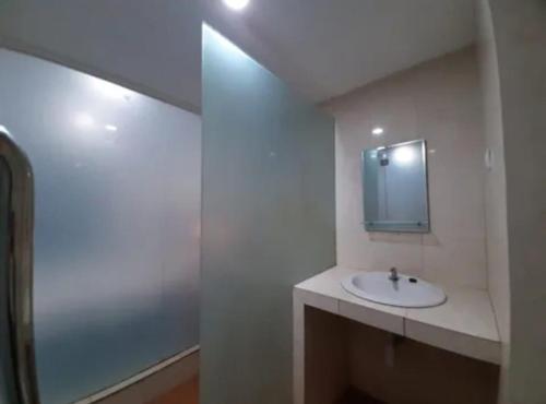 Baño blanco con lavabo y espejo en GUEST HOUSE UPY en Ngabean