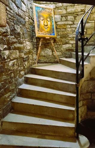 a painting of a face on a stand next to stairs at PiranArt Boutique Hotel & More in Piran