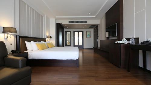 una camera d'albergo con letto e divano di The Dawin Hotel a Bangkok