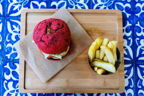 a sandwich and a bowl of fries on a wooden tray at Lisbon Marriott Hotel in Lisbon
