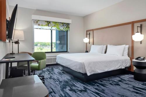 a hotel room with a bed and a desk and a window at Fairfield Inn & Suites by Marriott Corinth South Denton Area in Corinth