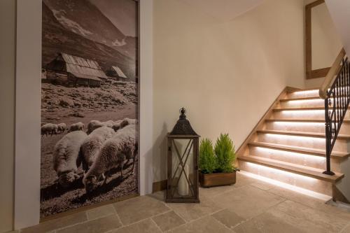 a hallway with a painting of sheep on the wall at Aparthotel Bambi in Zakopane