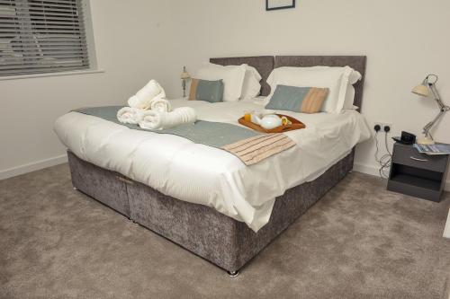 a large bed with towels and pillows on it at Select SA - Queens Terrace in Reading