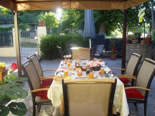 una mesa con comida en ella sentada bajo un paraguas en B&B Il Giardino, en Tavullia