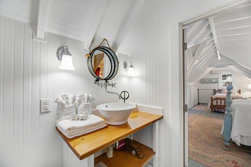 a bathroom with a sink and a mirror on a counter at Turquoise Cottage in Morehead City