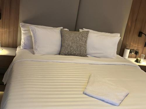 a large white bed with white pillows at Guided Hospitality - Luxury Accommodations in Lagos
