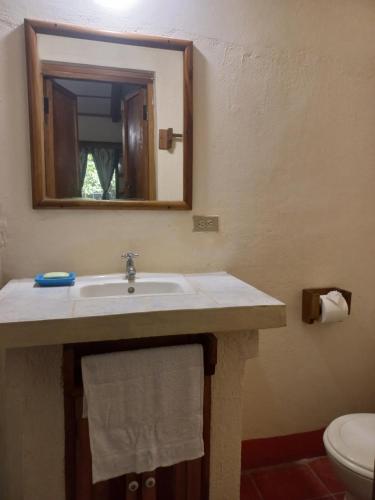 y baño con lavabo, espejo y aseo. en Hotel Casa Barcelona, en Granada