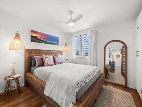 a bedroom with a large bed and a mirror at Lazy Days Penthouse - Opposite Shaws Bay - 180 Waterfront Views in East Ballina