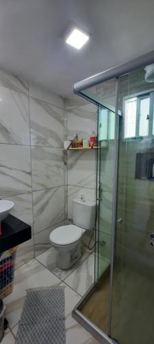 a bathroom with a toilet and a glass shower at Apartamento mobiliado in Recife