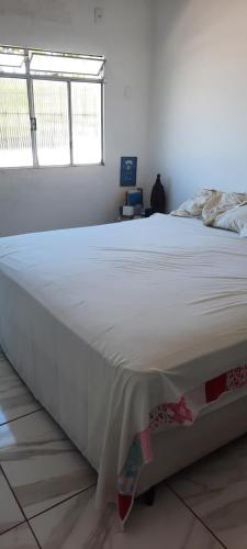 a large white bed in a bedroom with a window at Apartamento mobiliado in Recife