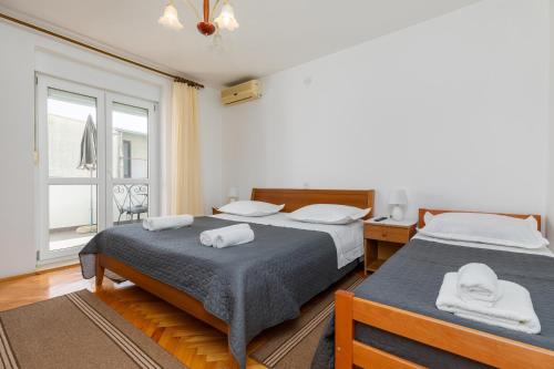 a bedroom with two beds and a window at Apartments with a parking space Omis - 2745 in Omiš