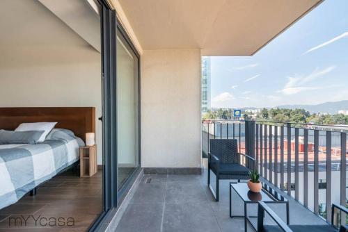 1 dormitorio con 1 cama y balcón con vistas. en Beautiful & comfortable Apt in Mexico City w/pool, en Ciudad de México