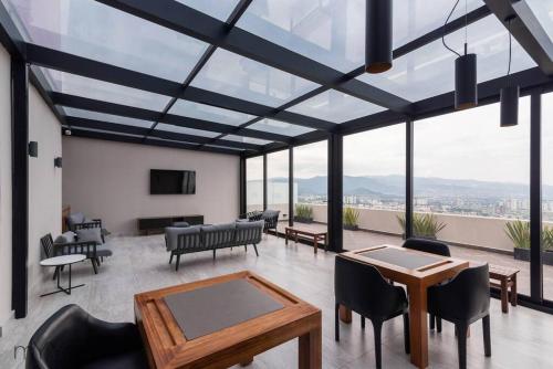 sala de estar con techo de cristal, mesa y sillas en Beautiful & comfortable Apt in Mexico City w/pool, en Ciudad de México