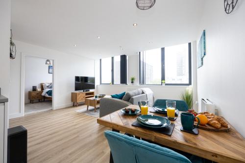 a living room with a table with food on it at Luxurious Stylish Apartment in Old Trafford in Manchester