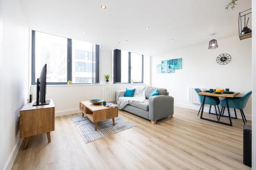 a living room with a couch and a tv and a table at Luxurious Stylish Apartment in Old Trafford in Manchester