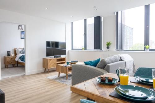a living room with a couch and a table at Luxurious Stylish Apartment in Old Trafford in Manchester