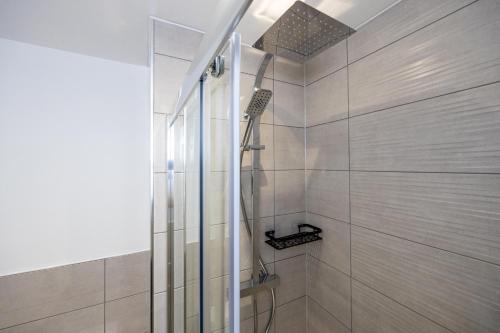 a bathroom with a shower with a glass door at Luxurious Stylish Apartment in Old Trafford in Manchester