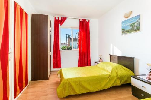 - une chambre avec un lit jaune et des rideaux rouges dans l'établissement Apartments by the sea Seget Vranjica, Trogir - 1038, à Seget Vranjica