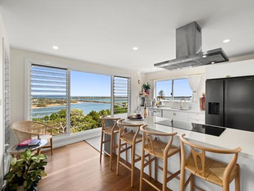 a kitchen and dining room with a view of the ocean at THE PENTHOUSE - Spectacular Views of the Bay, and the Ocean! Only 150m to Shaws Bay in East Ballina