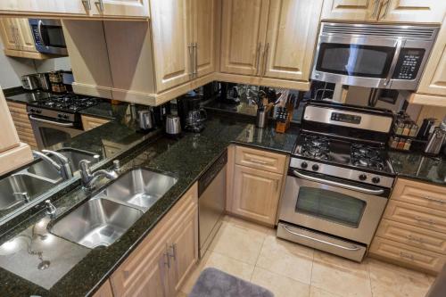 a kitchen with wooden cabinets and stainless steel appliances at Fabulous Penthouse Apartment LAS VEGAS Strip view with resort amenities! 5 min walk to main attractions! ONLY LONG TERM RENTALS min 31 days! in Las Vegas