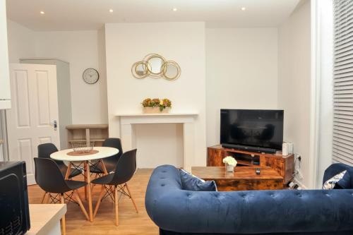 a living room with a blue couch and a table at Select SA - Queens Terrace in Reading