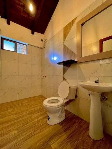 uma casa de banho com um WC e um lavatório em Room Privada Amanecer em Baños