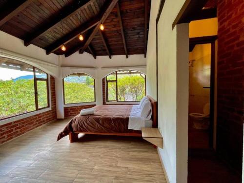 um quarto com uma cama num quarto com janelas em Room Privada Amanecer em Baños