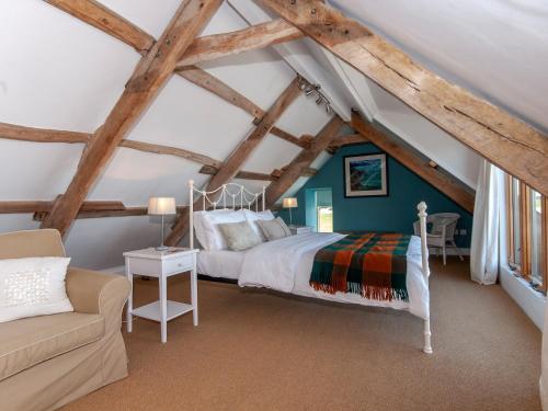 a bedroom with a bed and a couch in a attic at Lighthouse Watch in Saint Nicholas
