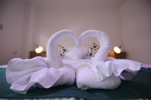 dos cisnes de toalla sentados en la parte superior de una cama en Dream Residences, en Manolo Fortich