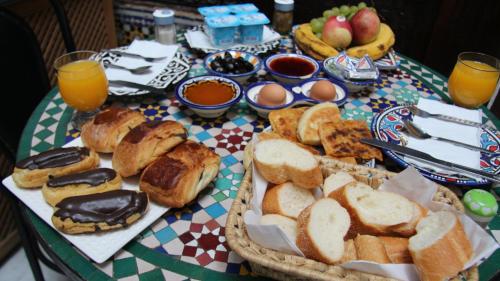 a table topped with a basket of bread and fruit at Riad Qamar Fez in Fez