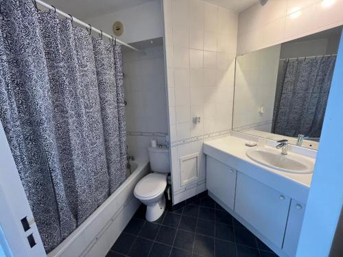 une salle de bain avec un lavabo, des toilettes et un miroir dans l'établissement Charmant T1 bis à Arcachon, 300m Plage de Pereire, Terrasse et Jardinet - FR-1-319-59, à Arcachon