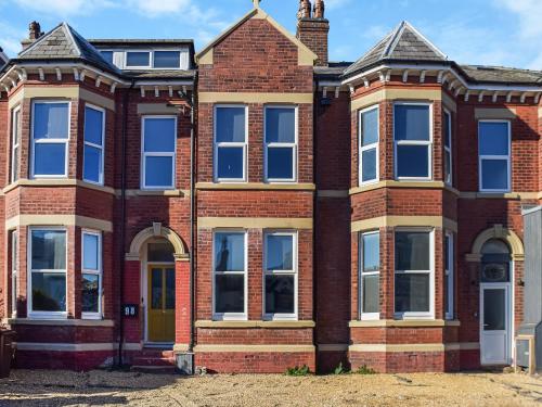 an old red brick house with a yellow door at Apartment One - Uk45352 in Southport