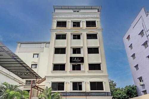 un grand bâtiment blanc avec un panneau sur celui-ci dans l'établissement Super Capital O Hotel Vaishnavi, à Secunderābād