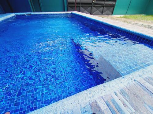 a swimming pool with blue tiles in the water at Arenal Palacios in Fortuna