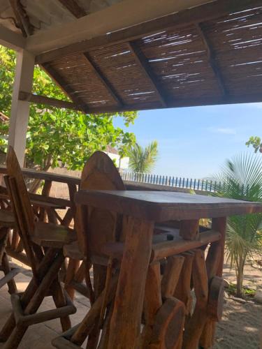 einen Holztisch und Stühle unter einer Pergola in der Unterkunft Casa de playa de Solano in Transito