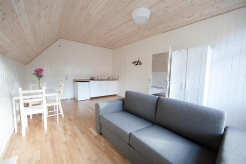 a living room with a couch and a table and a kitchen at Pervalkos vetrunges in Neringa