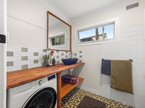 eine Waschküche mit einer Waschmaschine und einem Waschbecken in der Unterkunft Two Apartments Stray Leaves & The Jungle Room - 150m to Shaws Bay in East Ballina