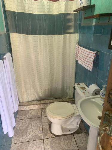 een badkamer met een toilet en een wastafel bij Casa de playa de Solano in Transito