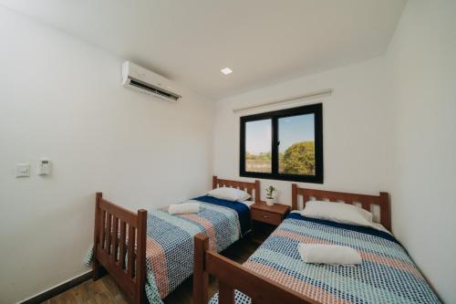 Duas camas num quarto com uma janela em Villas Oazis em Monterrico