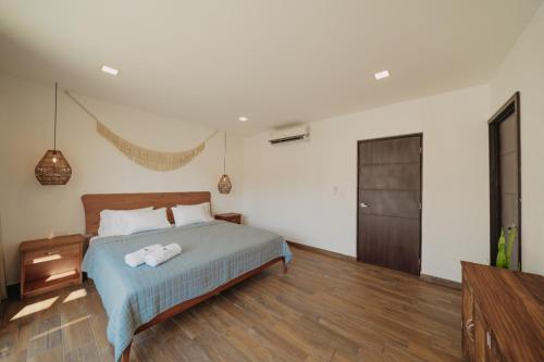 1 dormitorio con 1 cama y suelo de madera en Villas Oazis en Monterrico