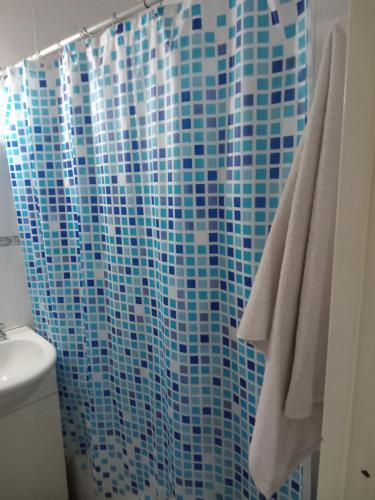 La salle de bains est pourvue d'un rideau de douche bleu et de toilettes. dans l'établissement La calera, à Azul