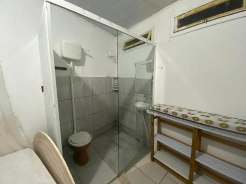 y baño con ducha de cristal y aseo. en Itajaí Hostel Pousada en Itajaí