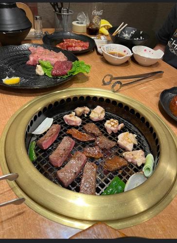 a grill with meat and other food on a table at O2 capsule house OTARU in Otaru