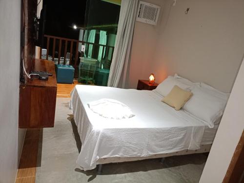 a bedroom with a white bed in a room at Paradise Beach in Fortim